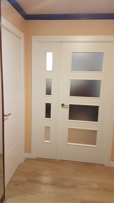Portes interiors lacades en blanc amb vidres per a habitatge a Lleida